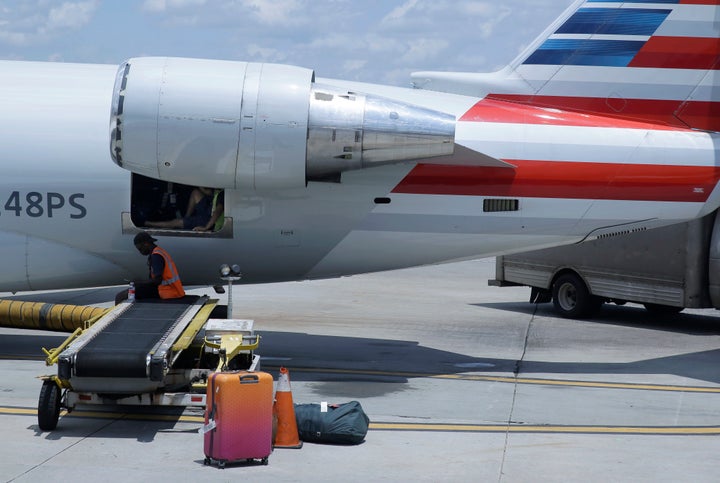 American Airlines grounds crew members sit and wait for luggage cart to arrive at Charlotte Douglas International Airport in Charlotte, N.C.