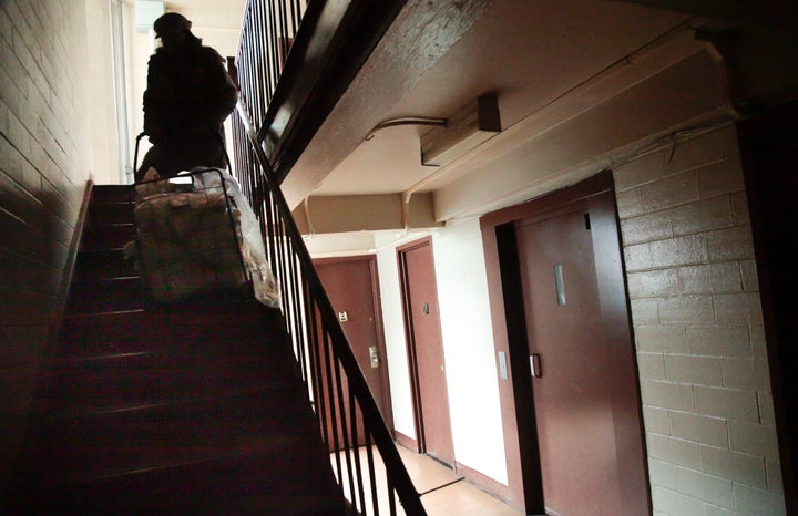 A woman pulls a cartload of groceries to her third-floor apartment in the Red Hook Houses residential complex in Brooklyn after Superstorm Sandy -- a storm linked to climate change -- knocked out power in 2012.