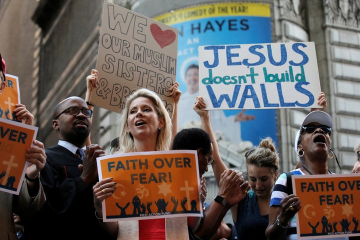 A group of interfaith religious leaders protests against then-presidential candidate Donald Trump outside a hotel where he me