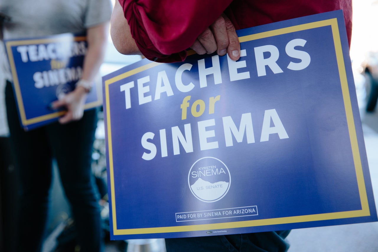 Supporters of #RedForEd hold signs touting Sinema on Oct. 24 in Phoenix.