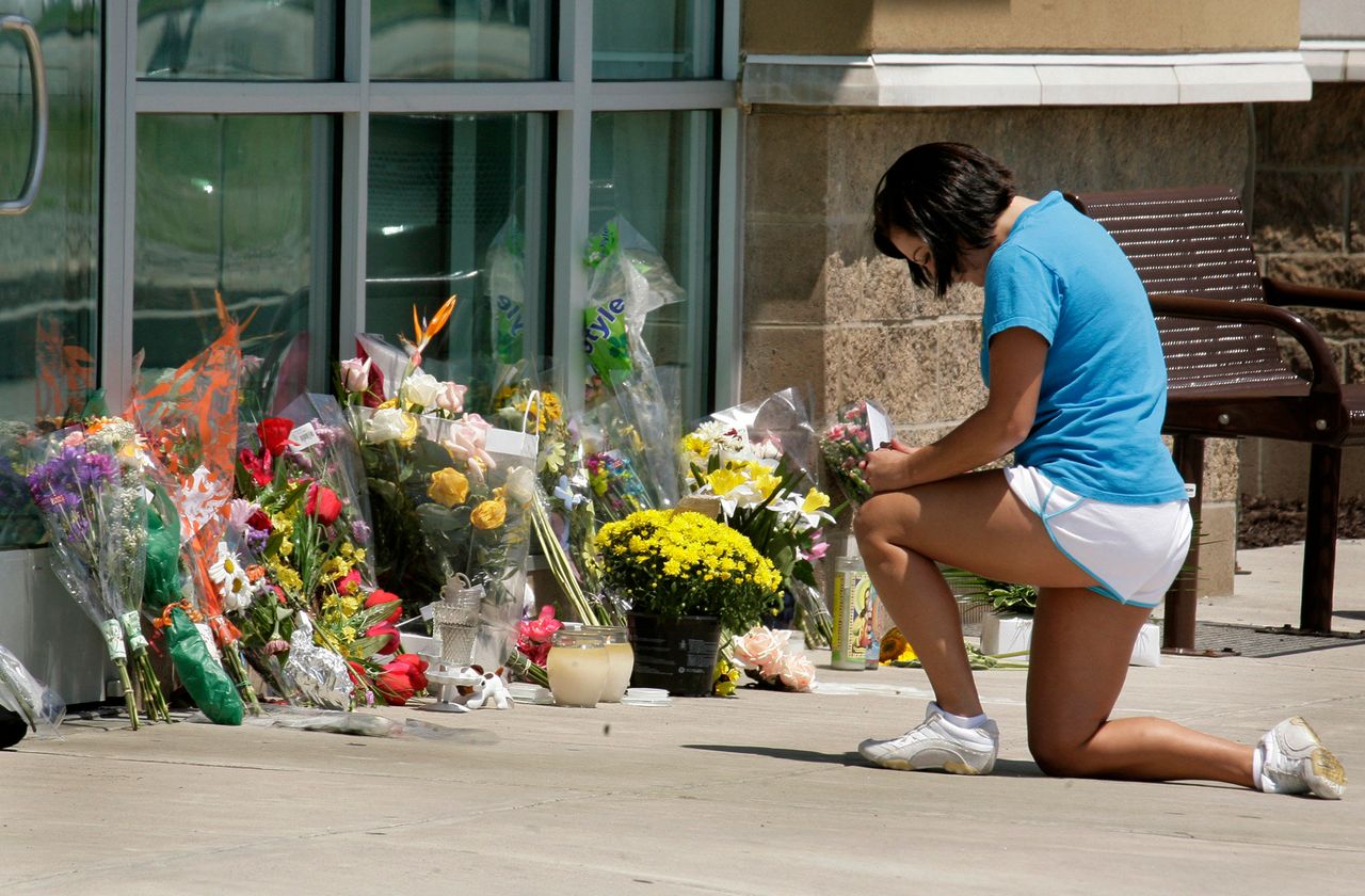 A woman places flowers outside an LA Fitness in Collier Township, Pennsylvania, on Aug. 6, 2009, after George Sodini opened fire on an aerobics class there, killing three women.