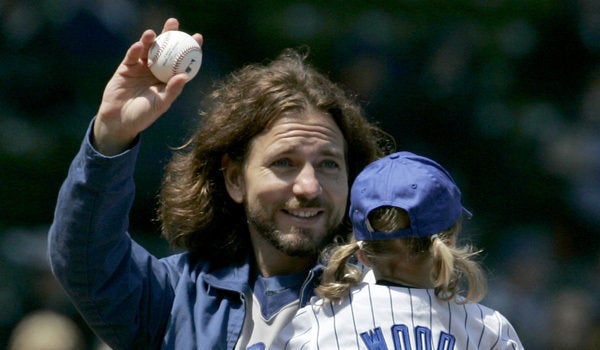 Pearl Jam frontman Eddie Vedder tries on a Chicago Cubs jersey as the