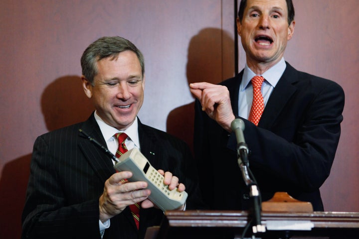 WASHINGTON, DC - OCTOBER 18: U.S. Sen. Mark Kirk (R-IL) (L) holds a Motorola cell phone from the 1980s during a news conference with U.S. Sen. Ron Wyden (D-OR) about the 25th anniversary of the Electronic Communications Privacy Act (ECPA) October 18, 2011 in Washington, DC. Wyden and U.S. Sen. Mark Kirk (R-IL) called for the ECPA legislation to be updated so to ensure that the government must get a warrant from a judge before tracking our movements or reading our private communications. (Photo by Chip Somodevilla/Getty Images)