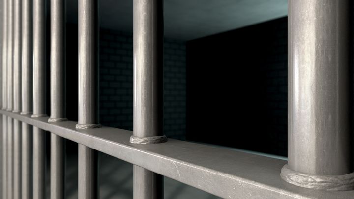 a closeup of a jail cells iron...