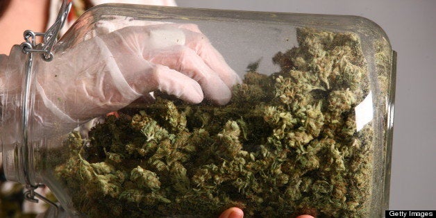 Lakewood, CO - MARCH, 4: Sales associate, Crystal Guess handles a jar of cannabis inside a Good Meds medical cannabis center