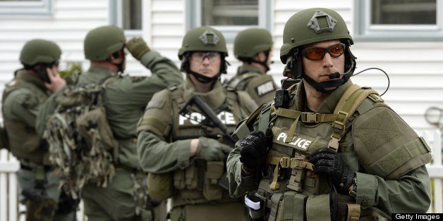 A police SWAT team search houses for the second of two suspects wanted in the Boston Marathon bombings takes place April 19, 2013 in Watertown, Massachusetts. Thousands of heavily armed police staged an intense manhunt Friday for a Chechen teenager suspected in the Boston marathon bombings with his brother, who was killed in a shootout. Dzhokhar Tsarnaev, 19, defied the massive force after his 26-year-old brother Tamerlan was shot and suffered critical injuries from explosives believed to have been strapped to his body. AFP PHOTO / TIMOTHY A. CLARY (Photo credit should read TIMOTHY A. CLARY/AFP/Getty Images)
