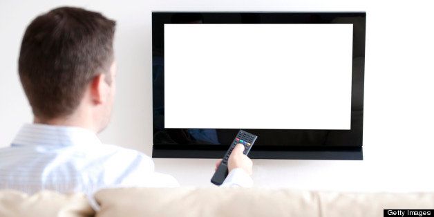 Man sits in sofa watching tv. He is pointing a remote at the tv. White screen: insert your own image easily.