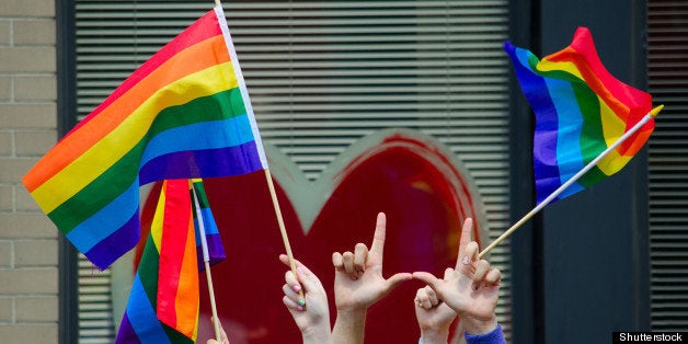 hands waving gay flags in front ...