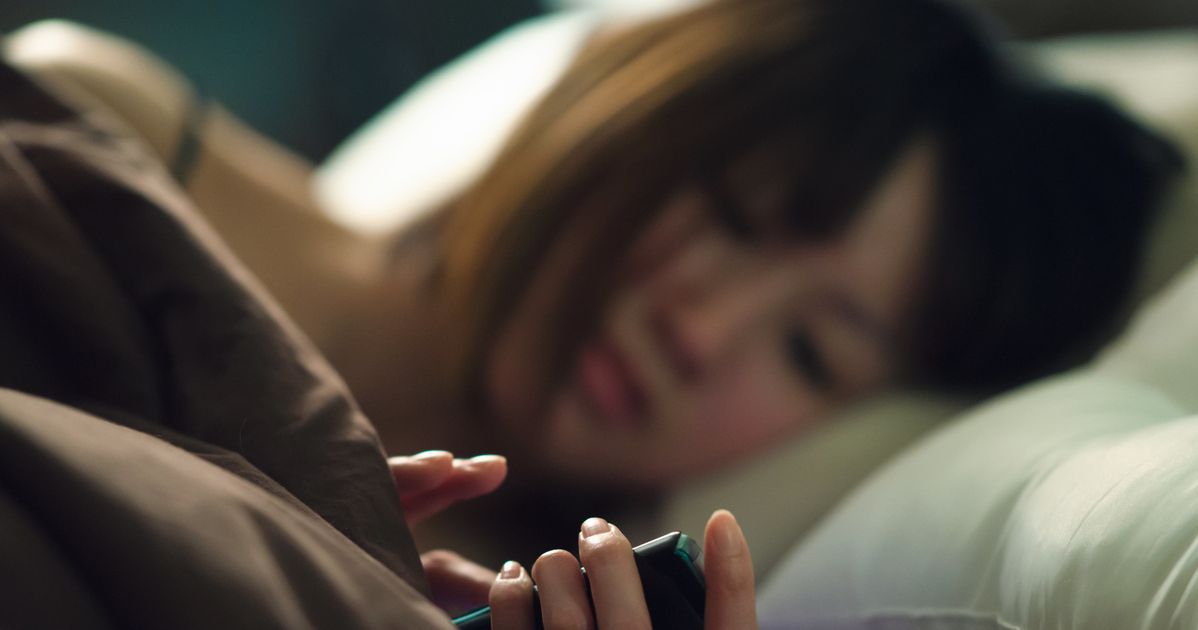 Девушка с мобильником в кровати