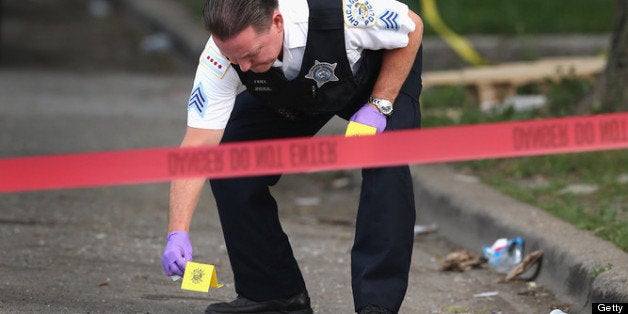 CHICAGO, IL - JULY 06: Police investigate a crime scene where seven people were shot on July 6, 2013 in Chicago, Illinois. Tw