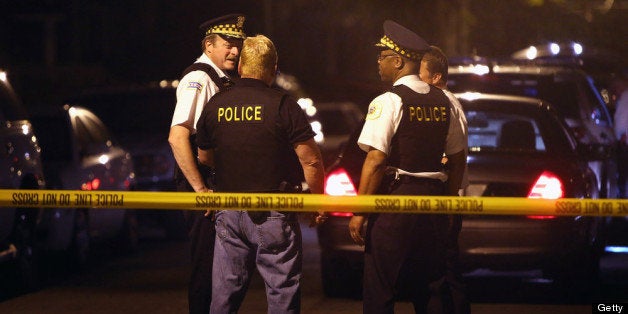 CHICAGO, IL - JUNE 17: Police investigate the scene where a 15-year-old boy was shot and killed by police after he reportedly pointed a gun at officers during a foot chase on June 17, 2013 in Chicago, Illinois. Two pistols were reported to have been found on the boy after the shooting. The boy was one of two people killed by police on Sunday. Over the Father's Day weekend at least 46 people were wounded and 8 killed by gunfire in the city. (Photo by Scott Olson/Getty Images)