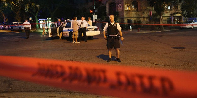 CHICAGO, IL - AUGUST 19: Chicago police investigate a shooting in front of the Uptown Baptist Church on August 19, 2013 in Chicago, Illinois. Five people were shot, one fatally, during the drive-by shooting in which gunmen fired more than 20 rounds at a group of people standing in front of the church. At least 9 people have been killed and about 30 others wounded in shootings in the city over the past 4 days. (Photo by Scott Olson/Getty Images)