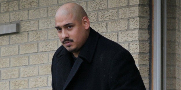 Gildardo Sierra, a Chicago police officer involved in three shootings this year, comes out of his home with his baby, in the