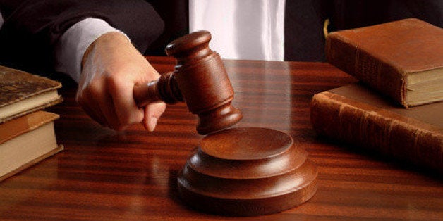 a judge hand striking a gavel over a table