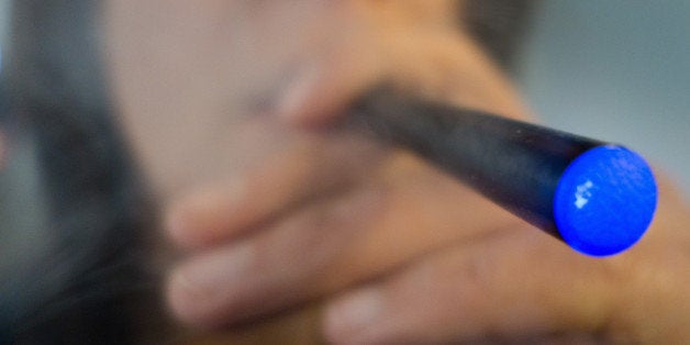 This September 25, 2013 photo illustration taken in Washington, DC, shows a woman smoking a 'Blu' e-cigarette (electronical c