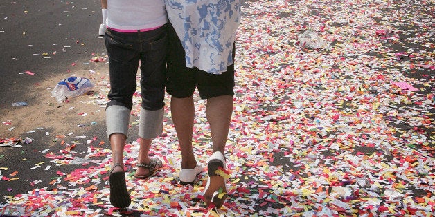 CHICAGO - JUNE 26: A gay couple strolls along a path of rainbow colored confetti in the city's gay district during the 36th