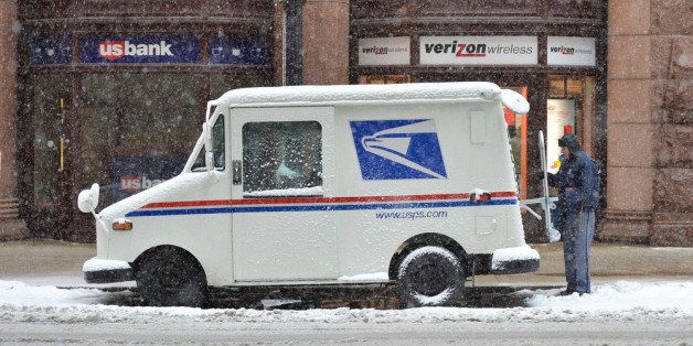 CHICAGO, IL - MARCH 5: A mail carrier loads his truck on March 5, 2013 in Chicago, Illinois. The worst winter storm of the season is expected to dump 7-10 inches of snow on the Chicago area with the worst expected for the evening commute. (Photo by Brian Kersey/Getty Images)