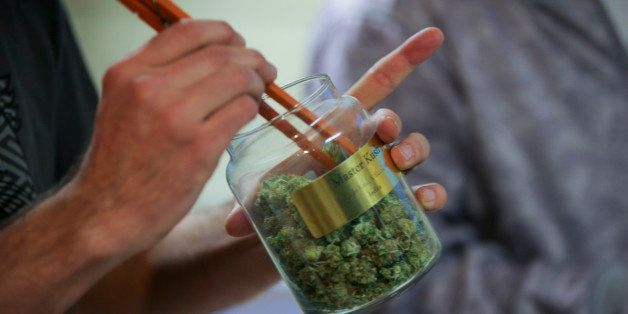 An employee pulls marijuana out of a large canister for a customer at the LoDo Wellness Center in downtown Denver, Colorado, U.S., on Thursday, Jan. 9, 2014. Colorado has just legalized the commercial production, sale, and recreational use of marijuana, while Washington State will begin its own pot liberalization initiative at the end of February. On Jan. 8, New York Governor Andrew Cuomo said his state would join 20 others and the District of Columbia in allowing the drug for medical purposes. Photographer: Matthew Staver/Bloomberg via Getty Images