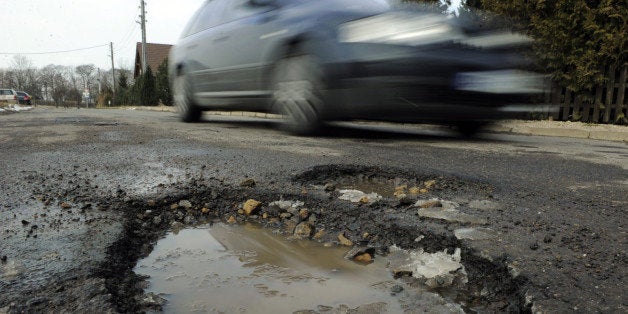 FILES - Picture taken on March 8, 2010 shows a car drving past a pothole in Niederzimmern, east central Germany. A novel idea by a hard-up east German village to sell its potholes to finance their repair looked on March 12, 2010 to have got off to a good start, with 111 already snapped up, the official website showed. AFP PHOTO DDP/ JENS-ULRICH KOCH GERMANY OUT (Photo credit should read JENS-ULRICH KOCH/AFP/Getty Images)