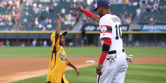 CHICAGO, IL - AUGUST 30: A member of the Jackie Robinson West Little League Team gets a high Five from Alexei Ramirez #10 of the Chicago White Sox after rounding the bases as the team is honored before the Chicago White Sox and Detroit Tigers game at U.S. Cellular Field on August 30, 2014 in Chicago, Illinois. (Photo by Jeffrey Phelps/Getty Images)
