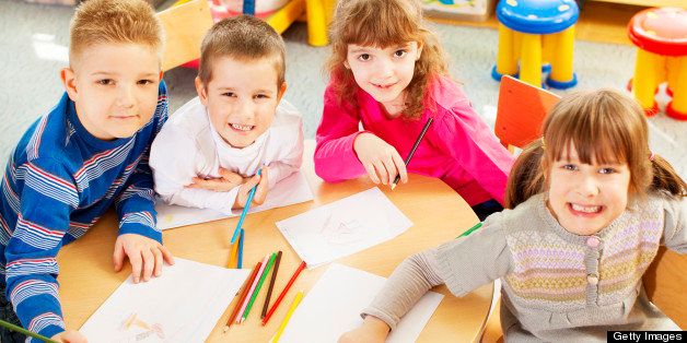 Preschool: Group of children drawing and coloring at preschool. Children looking at camera.