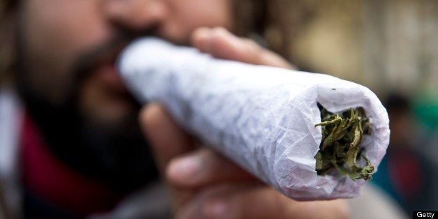 A man holds a giant joint during a march for the legalization of cannabis in Santiago, on May 18, 2013, as part of the 2013 Global Marijuana March which is being held in hundreds of cities worldwide. AFP PHOTO / Martin BERNETTI (Photo credit should read MARTIN BERNETTI/AFP/Getty Images)