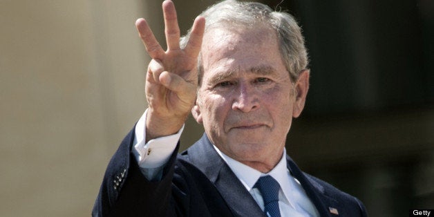 Former US President George W. Bush makes a 'W' with his fingers during a dedication ceremony at the George W. Bush Library an