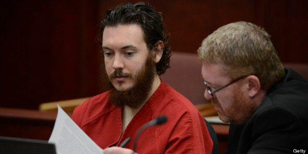 CENTENNIAL, CO - JUNE 04: James Holmes, left, glances over an advisement as his defense attorney, Daniel King, turns the pages in court Tuesday morning June 04, 2013 for an advisement hearing at the Arapahoe County Justice Center. Holmes is accused of killing 12 people and injuring 70 others in a shooting rampage at an Aurora theater, July 20th, 2012. The court accepted James Holmes plea of not guilty by reason of insanity and has ordered a sanity evaluation at the Colorado Mental Health Institute of Pueblo. (Photo By Andy Cross/The Denver Post via Getty Images)