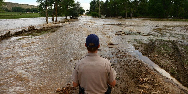 NORTH BOULDER, CO - SEPTEMBER 13: Colorado Parks and Wildlife officer Jason Duetsch looks at flooding across Oxford Road east of North 41st road in Boulder County on September 14, 2013. Massive flooding continues in 14 continues in Colorado. (Photo By Helen H. Richardson/ The Denver Post)