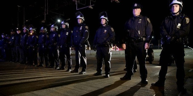 Police officers block protesters from marching up a highway entrance ramp in response to the grand jury's decision in the Eric Garner case in Times Square in New York, Wednesday, Dec. 3, 2014. The grand jury cleared a white New York City police officer Wednesday in the videotaped chokehold death of Garner, an unarmed black man, who had been stopped on suspicion of selling loose, untaxed cigarettes, a lawyer for the victim's family said. (AP Photo/Seth Wenig)