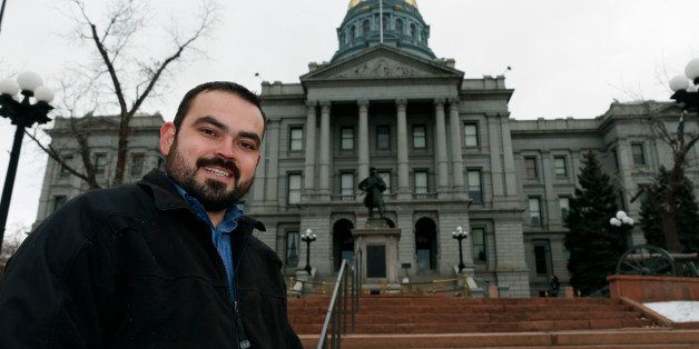 In this Tuesday, Dec. 23, 2014 photo, Edgar Antillon, one of the organizers of an effort to have a ballot measure placed before voters in the 2016 November election to allow marijuana users to carry concealed firearms, stands outside the State Capitol, in downtown Denver. The measure would change state law to prevent sheriffs from using marijuana use as a reason to deny a concealed carry permit to an applicant. (AP Photo/David Zalubowski)
