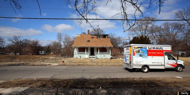 A U-Haul truck drives past a home scheduled to be demolished and turned into an urban garden in Detroit, Michigan, U.S., on Saturday, March 23, 2013. Motor City Blight Busters, is a non-profit group that brings volunteers together to participate on projects including painting homes, boarding up and securing abandoned buildings, renovating houses and helping build new ones. Photographer: Fabrizio Costantini/Bloomberg via Getty Images 