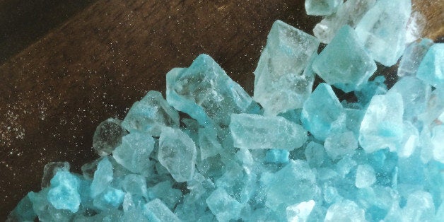 A large amount of crystal meth that has a blue color like the TV show Breaking Bad. The crystals are spilled out across a table. The image is vertical (stock image).