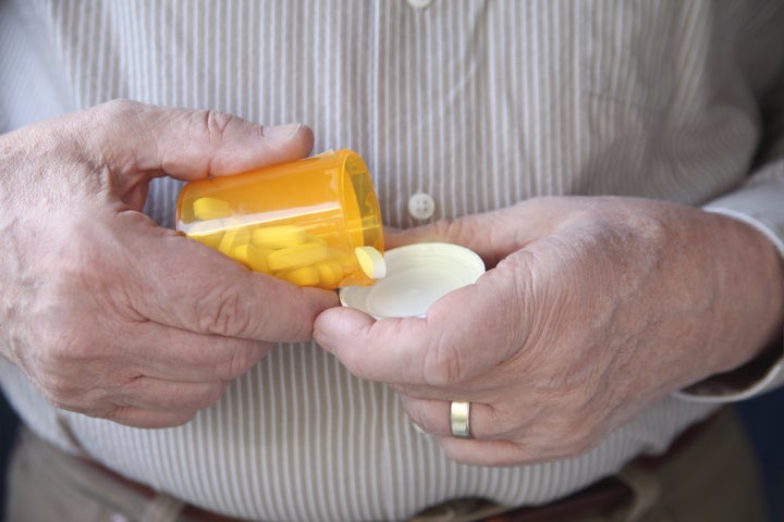 an older man gets ready to take a pill