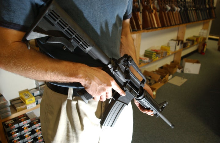 DENVER - SEPTEMBER 13: The manager of Dave's Guns holds a Colt AR-15, now legal with a Bayonet Mount, Flash Suppressor and a