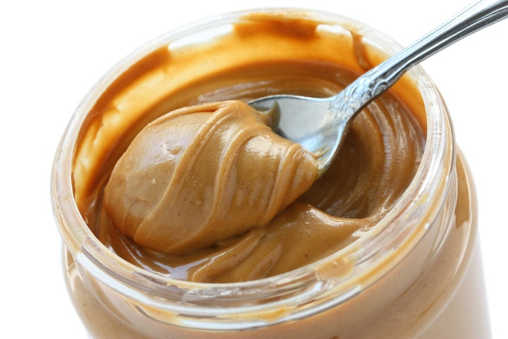 an open jar of peanut butter with spoon