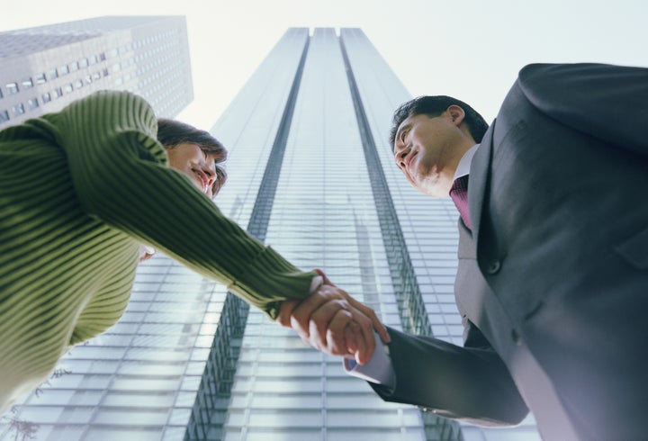 This man and woman are in Minato-ku, Tokyo, Japan. The building on the left is the Royal Park Shiodome Tower; the building on the right is the Nittele Tower, Oct 2004.