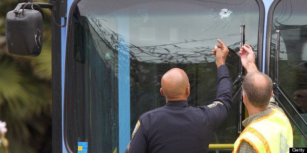 SANTA MONICA, CA - JUNE 07: A police officer and a transit official look at a bullet hole, one of many, in a public transit bus in which two passengers were shot, after multiple shootings were reported at various locations including Santa Monica College June 7, 2013 in Santa Monica, California. According to reports, at least six people have died in the shootings. (Photo by David McNew/Getty Images)