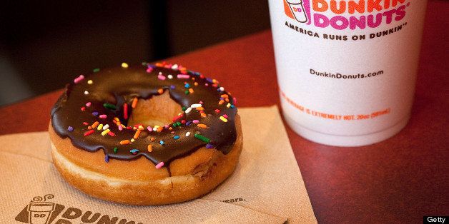A chocolate glazed donut and a cup of coffee are arranged for a photograph at a Dunkin' Donuts Inc. store in West Orange, New Jersey, U.S., on Thursday, July 7, 2011. Sales at U.S. retailers surpassed analysts' estimates last month as discounts and lower gas prices in the U.S. enticed consumers to spend. Photographer: Emile Wamsteker/Bloomberg via Getty Images