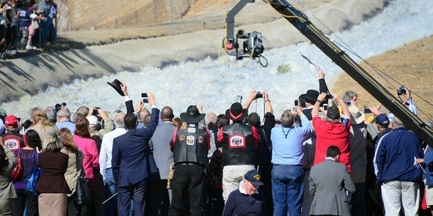 Hats are raised, as are cameras to record a re-enactment of the moment the Los Angeles Aqueduct gates were first opened 100 y