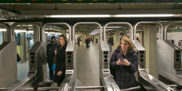 In this Dec. 4, 2013 photo, people move through the turnstiles in the subway in New York's Times Square station. Screeching s