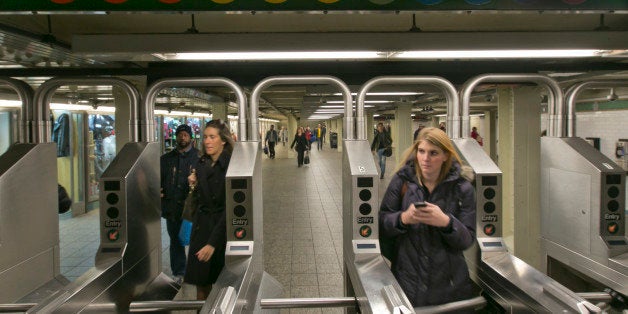 In this Dec. 4, 2013 photo, people move through the turnstiles in the subway in New York's Times Square station. Screeching subway trains emit considerable noise in a city with one of the nation's toughest noise codes. (AP Photo/Richard Drew)