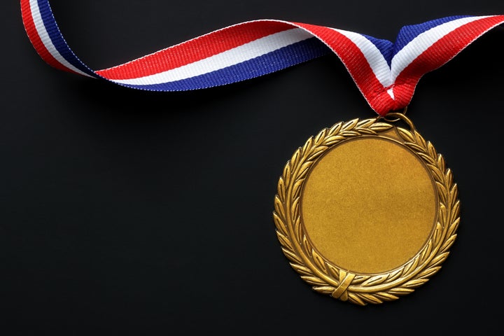 Gold medal on black with blank face for text, concept for winning or success