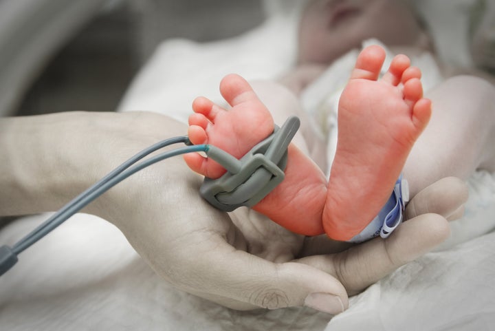 mother's hand holding feet of...