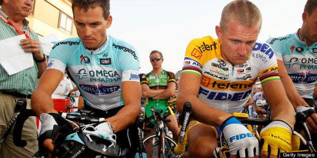 Czech Zdenek Stybar of team Omega Pharma - Quick Step (L) and Belgian Bart Wellens of Telenet - Fidea bow their heads during a minute of silence before the 8th edition of the Natourcriterium van Herentals cycling race on July 26, 2012 in Herentals. The moment of silence was held in honor of Belgian cyclist Rob Goris, who died of a heart attack on July 5. AFP PHOTO / BELGA / KRISTOF VAN ACCOM --BELGIUM OUT-- (Photo credit should read KRISTOF VAN ACCOM/AFP/GettyImages)