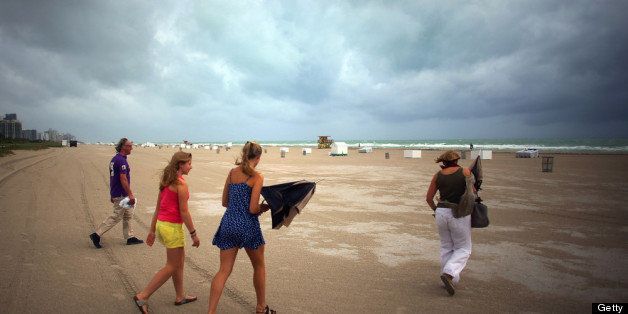 MIAMI BEACH, FL - OCTOBER 25: (L-R) William Rath, Julie Rath, Weera Rath and Laura Rath, on vacation from the Netherlands, walk on the beach as they are buffeted by high winds of the outer bands of Hurricane Sandy on October 25, 2012 in Miami Beach, Florida. After passing over Jamaica Hurricane Sandy is expected to hit eastern Cuba and head into the Bahamas today and tomorrow. There is a tropical storm warning in place for coastal Miami-Dade, Broward, and Palm Beach Counties and the Atlantic waters off southeast Florida. (Photo by Joe Raedle/Getty Images)
