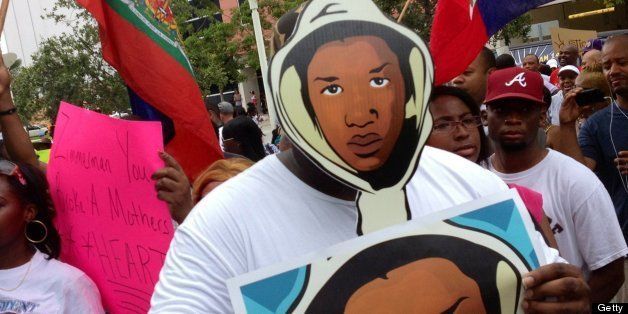 Aqua Etefia attends a 'Justice for Trayvon' rally, holding Trayvon Martin signs, at the Wilkie D. Ferguson, Jr. United States Federal Courthouse in Miami, Florida, Saturday July 20, 2013. Trayvon's father, Tracy Martin, was on hand to speak to a large crowd of people unhappy with the verdict. (Emily Michot/Miami Herald/MCT via Getty Images)