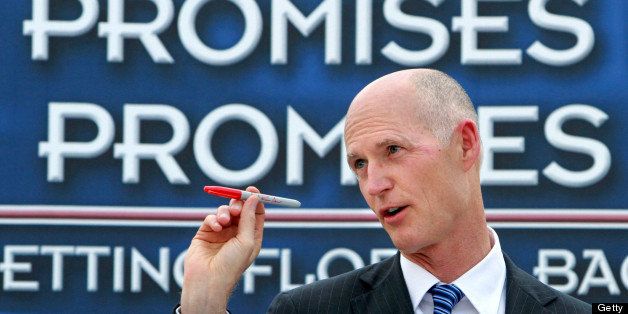Florida Republican Gov. Rick Scott holds up his red veto pen to make a point during remarks before signing the state budget, during an outdoor ceremony in The Villages, Florida, Thursday, May 26, 2011. (Joe Burbank/Orlando Sentinel/MCT via Getty Images)