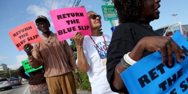 MIAMI, FL - DECEMBER 17: People gather on the sidewalk in front of the office of Sen. Marco Rubio (R-FL) to ask him to drop