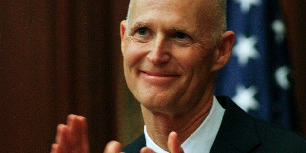 Florida Gov. Rick Scott applauds a guest during his State of the State speech Tuesday, March 4, 2014 on the floor of the House of Representatives at the Capitol in Tallahassee, Fla. The regular session continues until May 2. (AP Photo/Phil Sears)